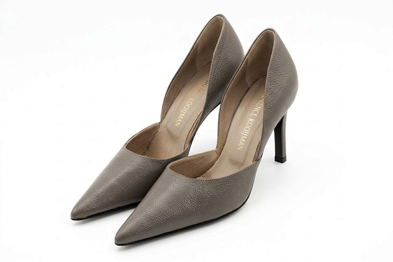 Sophisticated d'Orsay pumps with an open arch cut, designed to elongate the leg with effortless grace, in taupe leather with pointed toe and high slim heel